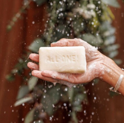 Dr. Bronner's bar soap in hand