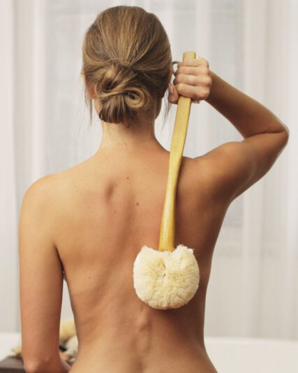 Women using Ecomax body brush to clean her back