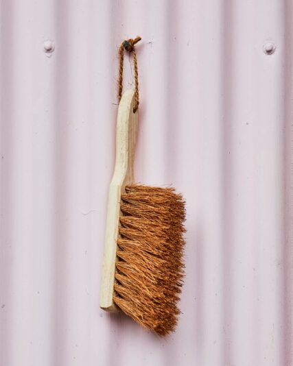 Ecomax dust brush hanging from outside hook on wall