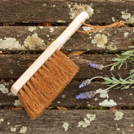 Ecomax dust brush on timber deck with flowers